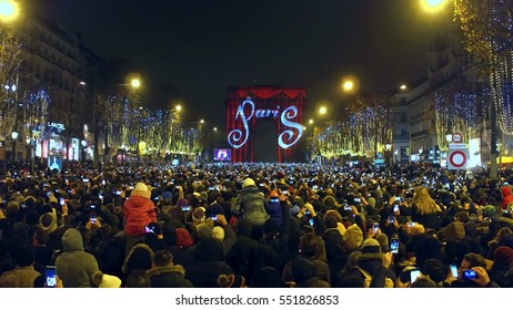 PARIS, FRANCE - DECEMBER, 31, 2016. Overhead Shot Of Crowded Champs-Elysees Street And Light Show On Famous Triumphal Arch, Arc De Triomphe. New Year's Eve