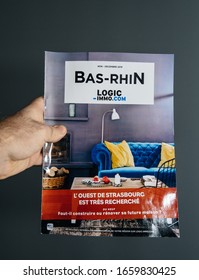 Paris, France - Feb, 25, 2020: Man Hand Holding Against Gray Background New Logic Immo.com Real Estate French Magazine For The Bas-Rhin Region