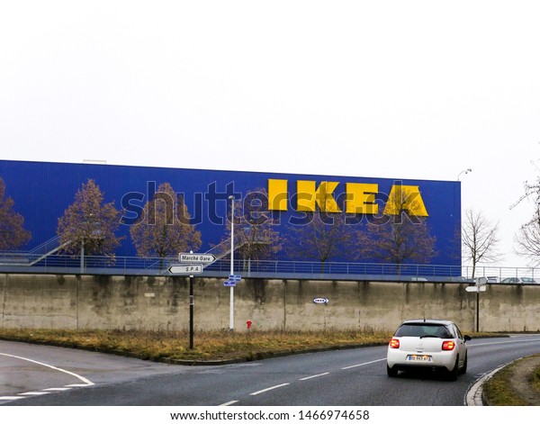 Paris, France - Feb 4, 2019: Citroen car\
driving fast highway entrance with IKEA furniture supermarket store\
in the background