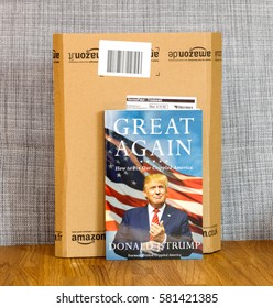 PARIS, FRANCE - FEB 9, 2017: Great Again - How To Fix Our Crippled America Biography Book By Donald J Trump In Front Of Amazon Delivery Box. Crippled America:  Is A Book By Donald Trump