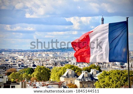 Paris, France Flag with Eiffel tower peeking in the back.