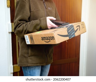 Paris, France - Jan 27, 2016: Side View Of UPS Female Worker Scanning Parcel From Amazon Prime Delivery Before Deliverying Shipment To Customer Through The Open Door