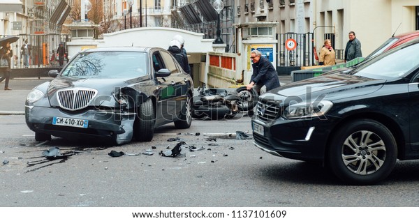 PARIS, FRANCE - JAN 30, 2018: Front view of\
car accident on Paris street between luxury limousine Lancia Thesis\
and scooter moped transporting medical transfusion blood - rue de\
Courcelles