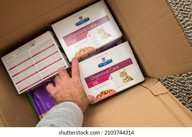 Paris, France - Jan 7, 2022: POV Male Hand Unboxing Unpacking Package Of Cat Wet Food - Hills Prescription Diet Digestive Care I D With Salomon Taste