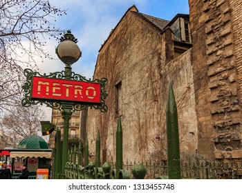 Paris, France - January 22, 2015: Ornate Red Art Deco Or Art Nouveau Parisian Metro Sign Near By The Side Of The Saint Germain Des Pres Church And Merto Stop