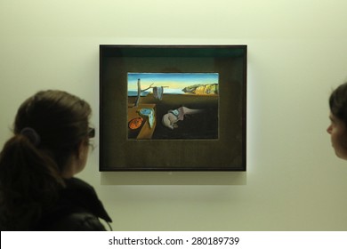 PARIS, FRANCE - JANUARY 7, 2013: Visitors look at the painting The Persistence of Memory (1931) by Salvador Dali displayed at his retrospective exhibition in Paris, France. 