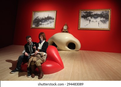 PARIS, FRANCE - JANUARY 7, 2013: Visitors Take A Picture As They Sit At The Mae West Lips Sofa By Salvador Dali Displayed At His Retrospective Exhibition In Paris, France.