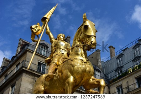Paris, France. Jeanne d’Arc (Joan of Arc) golden statue. Blue sky with white clouds.