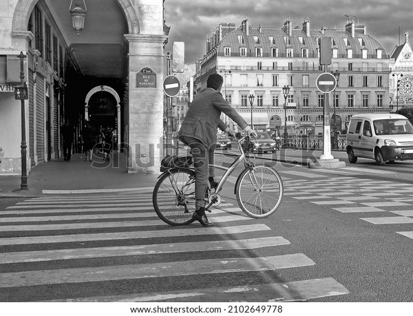 PARIS,\
FRANCE - JULY 11, 2006: Healthy businessman in suit makes city trip\
by bike on July 11, 2006 in Paris,\
France.\
