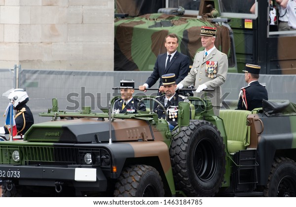 PARIS,\
FRANCE - JULY 14, 2019 :  President Emmanuel Macron with Chief of\
the french Army General Francois Lecointre arrive in a command car\
for the traditional Bastille Day military\
parade.