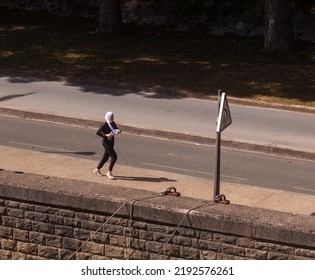 Paris, France - July, 14: Young Muslim Sportswoman In Hijab Running On Jogging Track On 14 July, 2022