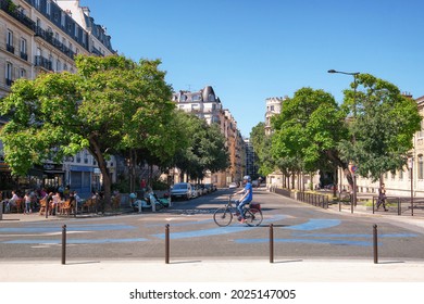 Paris, France - July 18 2021 : Cyclist In A Parisian Street With A Café Terrace