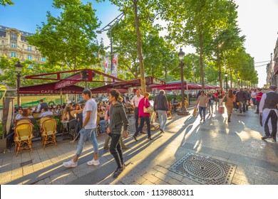 Paris, France - July 2, 2017: Tourists Walk On The Most Famous Avenue Of Paris, The Champs Elysees, For Shopping In Luxury Shops. Lifestyle People Sitting At Cafe George V.