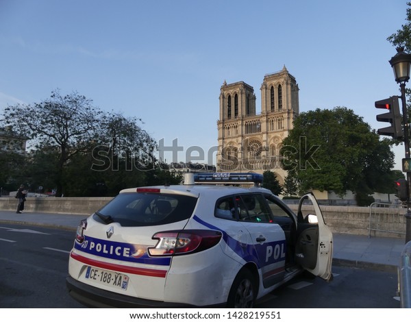 Paris,\
France - July 2019: Police car near Notre Dame de Paris. View of\
the burnt down Noter Dame de Paris. Police\
patrol.