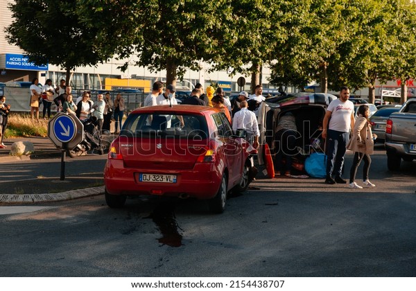 PARIS, FRANCE - July, 2021: Car accident on Paris\
city at intersection of magasin GiFi. People trying to get people\
out of the overturned\
car.