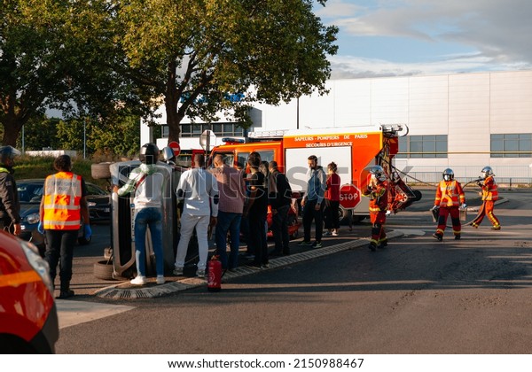 PARIS, FRANCE - July, 2021:\
Cars crash accident. People help firefighters a overturned car in\
city.