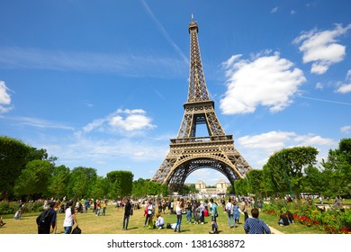 PARIS, FRANCE - JULY 21, 2017: Eiffel Tower In Paris And Green Field Of Mars Meadow With People And Tourists In A Sunny Summer Day, Blue Sky