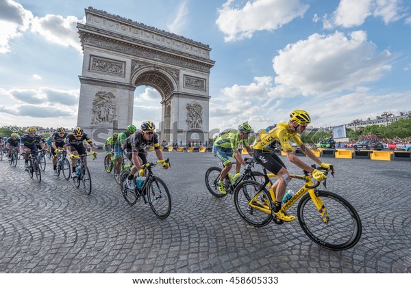 PARIS, FRANCE - JULY 24, 2016 : The road racing\
cyclist Christopher Froome, wearing the leader\'s yellow jersey in\
front of Arc de Triomphe during the Tour de France 2016 on the\
Champs Elysees Avenue.