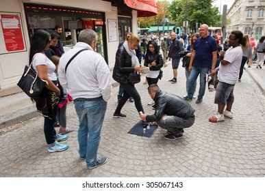 PARIS, FRANCE - JULY 28, 2015: A Man Is Playing A Conjuring Trick Game What Is Illegal On A Street In Paris In France