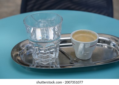 Paris, France - July, The 6th 2021: A Close-up On An Expresso Coffee And A Glass Of Water On The Table Of A Parisian Café.