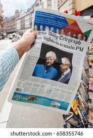 PARIS, FRANCE - JUN 12, 2017: Buying At Press Kiosk The Daily Telegraph Newspaper With Reactions To United Kingdom General Election Of 2017 - Theresa May Fights To Remain PM