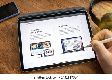 Paris, France - Jun 6, 2019: Man Reading On Apple IPad Pro Tablet About Latest Announcement Of At Apple Worldwide Developers Conference WWDC - Showing The MacOS Catalina