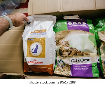 Paris, France - Jun 6, 2019: POV Male Hand Unpacking Unboxing Parcel Cardboard With Multiple Cat Pet Food - Royal Canin And Cat's Best Litter Inside