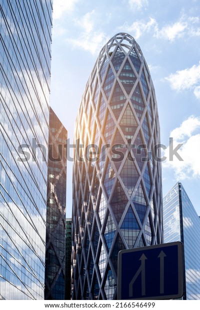 Paris, France - June 12, 2022: Glass facades of a\
skyscraper on a bright sunny day with sunbeams in the blue sky. A\
modern building in the La Defense business district of Paris.\
Economy, finance, busi