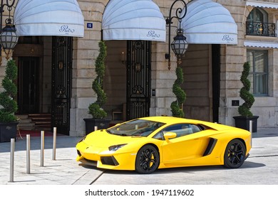 Paris, France, June 22: A bright yellow car is parked outside the front entrance of the Ritz Hotel on June 22, 2012 in Paris. From the series life of a big city.