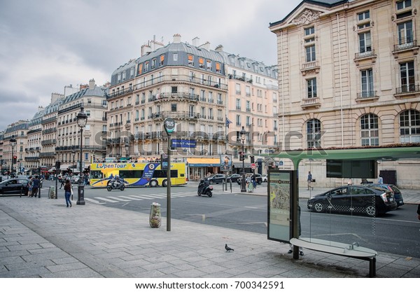 Paris,  France - June 3, 2017: Empty bus stop\
Mairie du 5e-Pantheon located at Rue Soufflot. Sightseeing tour bus\
moves the middle. There are attractive buildings with attic roofs\
in the background