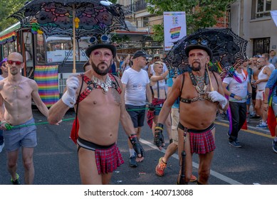 PARIS, FRANCE - JUNE 30, 2018: Older Men Couple Walking Up The Street With Umbrellas During The 2018 Gay Pride.