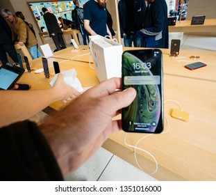 Paris, France - Mar 19 2019: Man POV Personal Perspective Holding IPhone XS Inside The New Apple Store Champs-Elysees Largest French Store Located In The Heart Of The Capital Focus On Shopping People