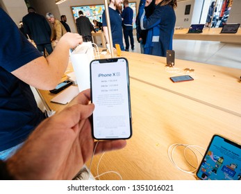 Paris, France - Mar 19 2019: Man POV Defocused Personal Perspective Holding IPhone XS Inside The New Apple Store Champs-Elysees - French Flagship Store Building