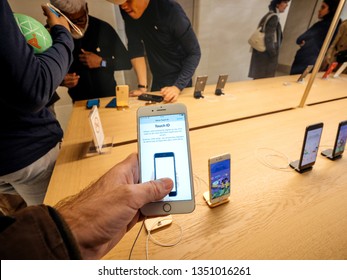 Paris, France - Mar 19 2019: Man POV Personal Perspective Holding IPhone 7 Plus Inside The New Apple Store Champs-Elysees Largest French Store Located In The Heart Of The Capital Testing Touch ID