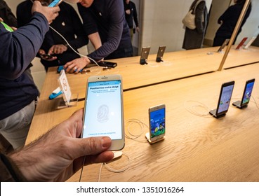 Paris, France - Mar 19 2019: Man POV Personal Perspective Holding IPhone 7 Plus Inside The New Apple Store Champs-Elysees Largest French Store Located In The Heart Of The Capital Testing Touch ID