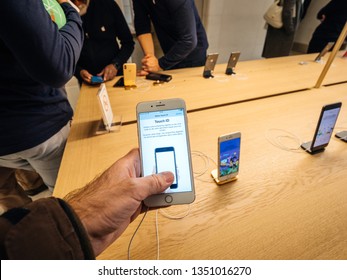 Paris, France - Mar 19 2019: Man POV Personal Perspective Holding IPhone 7 Plus Inside The New Apple Store Champs-Elysees Largest French Store Located In The Heart Of The Capital Testing Touch ID