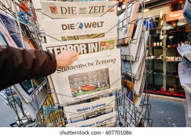 PARIS, FRANCE - MAR 23, 2017: Man buys Suddeutsche Zeitung and other international magazines covers at press kiosk newsstand headlines following the terrorist in London at the Westminster Bridge  