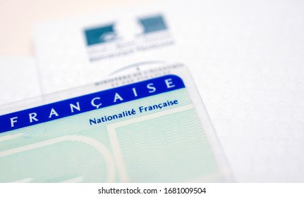 Paris, France - Mar 31, 2019: Tilt Shift lens close-up macro shot of National identity card Carte nationale d identite with letter from the ministry of interior in the background
