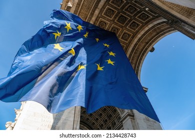 Paris, France - March 10 2022: European Union flag flying in the wind under the Arc de Triomphe in March 2022 for a special EU summit on Ukrainian crisis