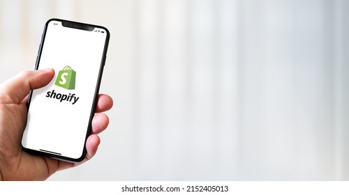 Paris - France - March 15, 2022 : Hand Holding Iphone Smartphone With Shopify Logo. Horizontal Banner