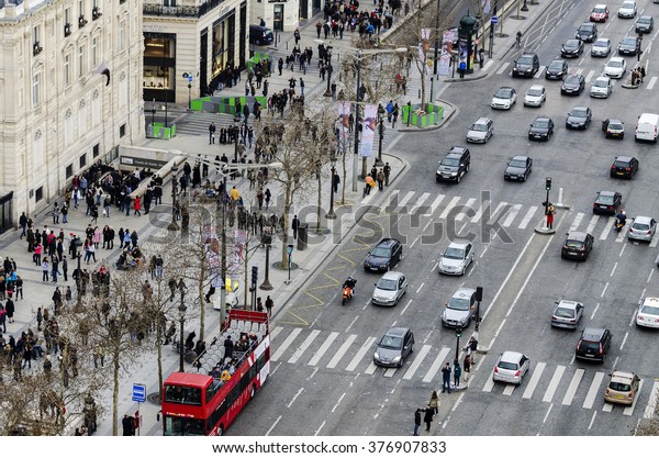 Paris, France - March 17, 2012: view\
of group of people walking on the Crosswalk to Champs Elysees in\
Paris, France. Photo shoot done from the triumphal\
arch