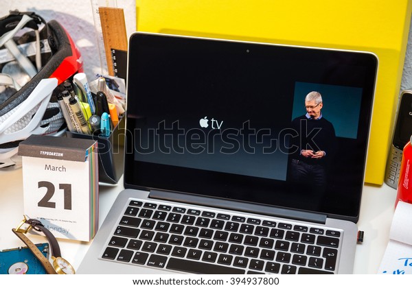 PARIS, FRANCE - MARCH 21,\
2016: Apple Computers website on MacBook Pro Retina in a creative\
room environment showcasing Apple Event with Tim Cook and Apple Tv\
logo