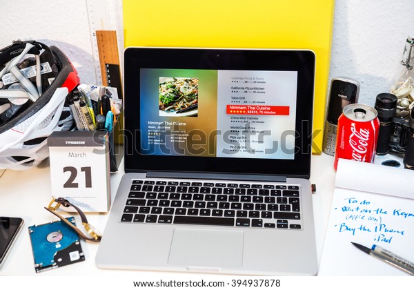 PARIS, FRANCE - MARCH 21,\
2016: Apple Computers website on MacBook Pro Retina in a creative\
room environment showcasing Apple Event with Food ordering app on\
Apple TV