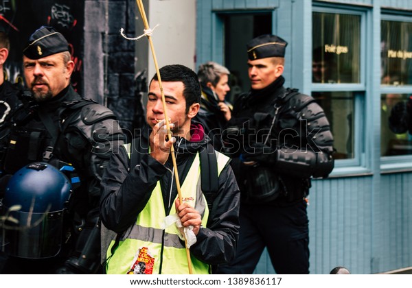 Paris France May 04, 2019\
View of Yellow Jackets protesters framed by anti riot police\
marching against President Macron\'s policy in Paris on saturday\
afternoon