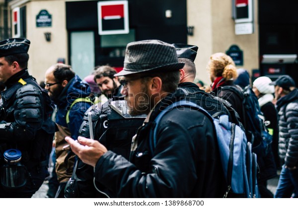 Paris France May 04, 2019\
View of Yellow Jackets protesters framed by anti riot police\
marching against President Macron\'s policy in Paris on saturday\
afternoon