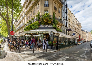 Paris, France - May 19, 2021: Day after lockdown due to covid-19 in a famous Parisian cafe. 2 waiters wear surgical masks