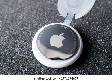 Paris, France - May 2, 2021: Tilt-shift lens over Hero object shot of new AirTag with mirrror back engravings ultra wideband and designed by Apple Computers in California with logotype Bluetooth LE