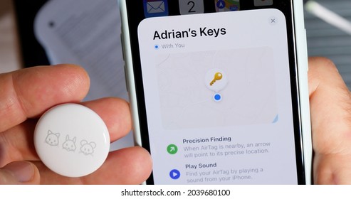 Paris, France - May 2, 2021: Man pov setting up AirTag setup on the iPhone - small device helps people keep track of belongings, using Apple Find My network to locate lost items like keys, wallet, bag