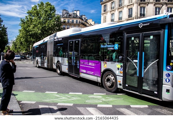 Paris, France - May 21, 2022 Bus driving\
through the streets of Paris during the coronavirus outbreak\
hitting France, wearing a mask is\
mandatory