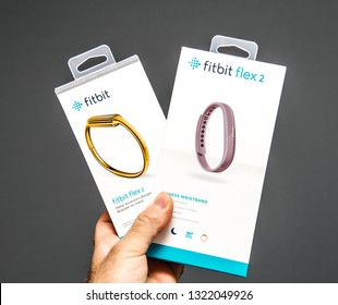 Paris, France - May 29, 2018: Male hand holding Fitbit Flex and Fitbit Flex wristband female sports tracker personal wearable device